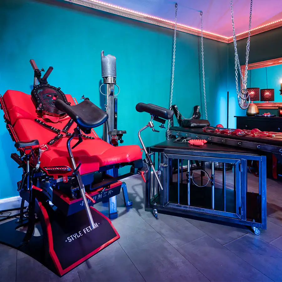 Ein exklusiver Raum in unserem Fetisch-Studio in Aachen, ausgestattet mit hochwertigem Equipment für anspruchsvolle Sessions. Der Gynstuhl-Boomer von StyleFetish, eine BDSM-Liege und ein Andreaskreuz bieten vielseitige Möglichkeiten für kontrollierte Rollenspiele in stilvollem Ambiente.