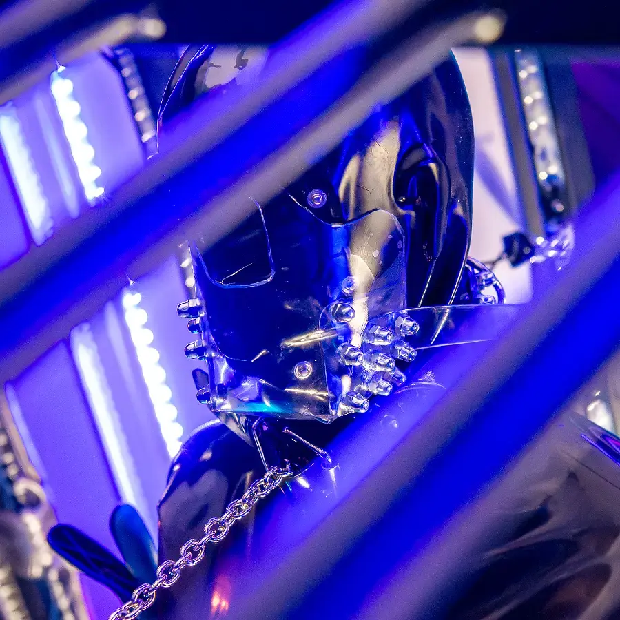 Detailaufnahme einer fixierten Person in Latexmaske und Kette im Dominastudio Golden Cage Aachen NRW